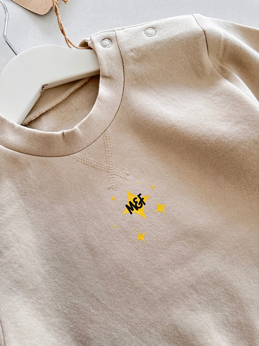 Beige fabric with a small yellow logo on a light gray background